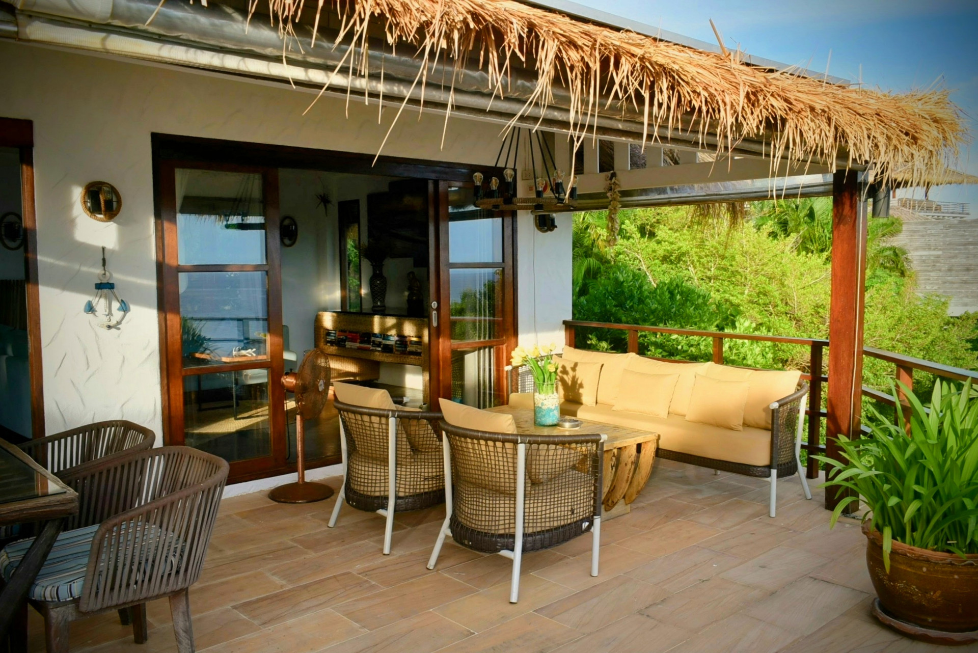 Terrace lounge with thatched roof and greenery at The Fisherman’s House